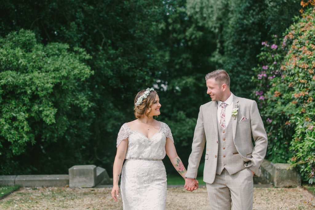 Relaxed Hampton Manor wedding photography. Bride and Groom walk and look at each other, holding hands