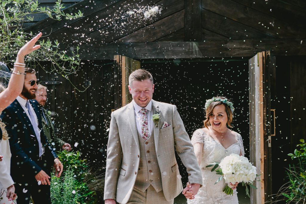 A newly married couple exit their Hampton Manor wedding ceremony to a confetti shower