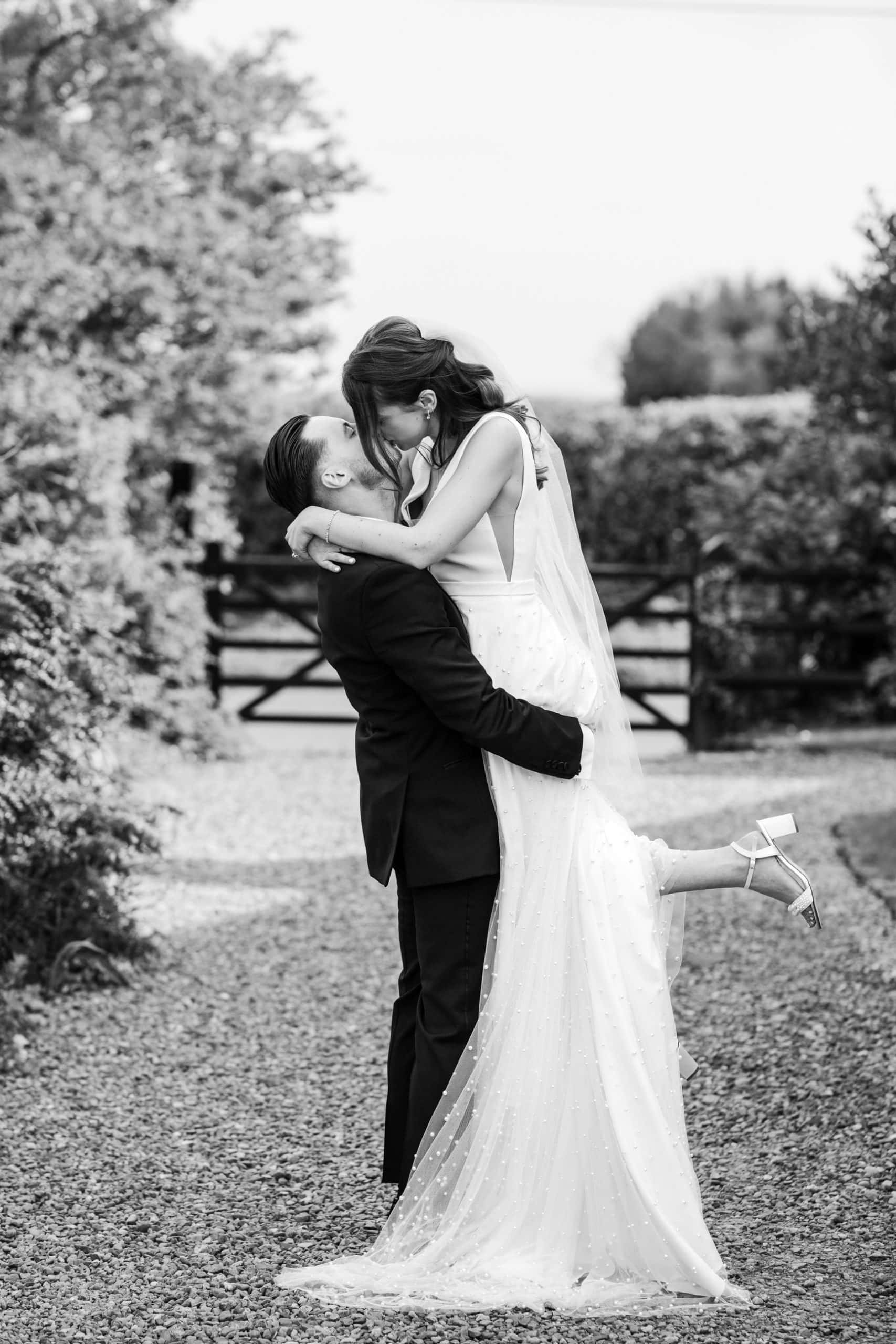 Groom picking up his bride and kisses her