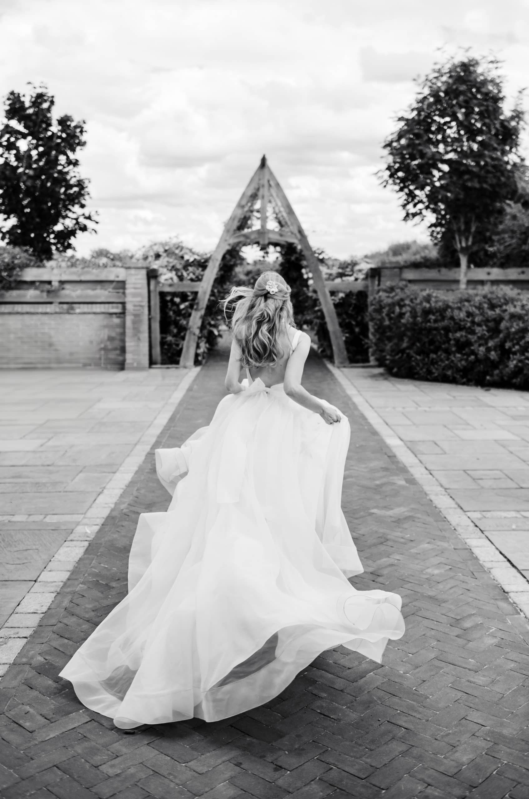 Bride runs holding and swishing her dress in a Cinderella style moment