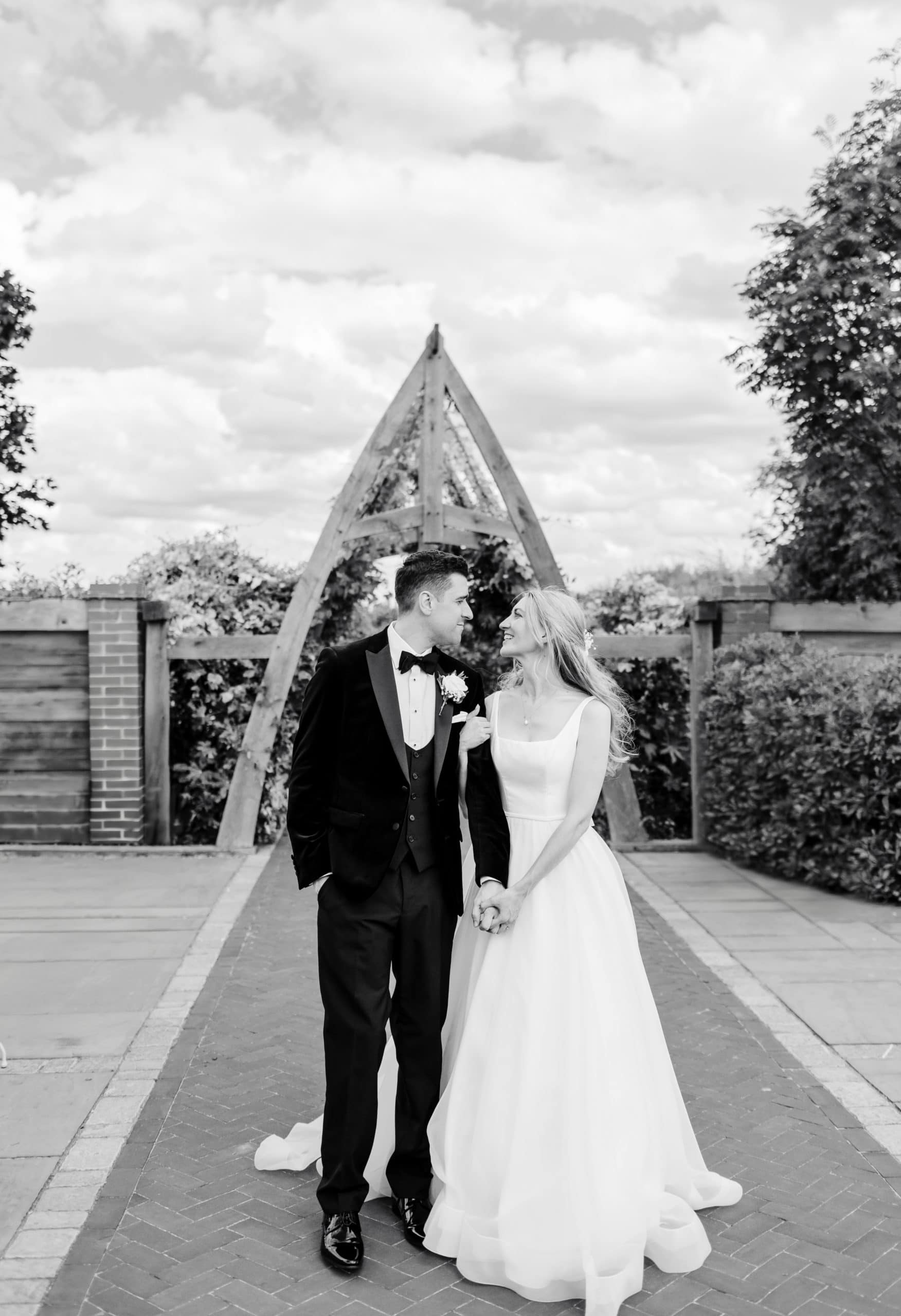 newly married Groom and Bride, linking arms and walk together, looking at each other