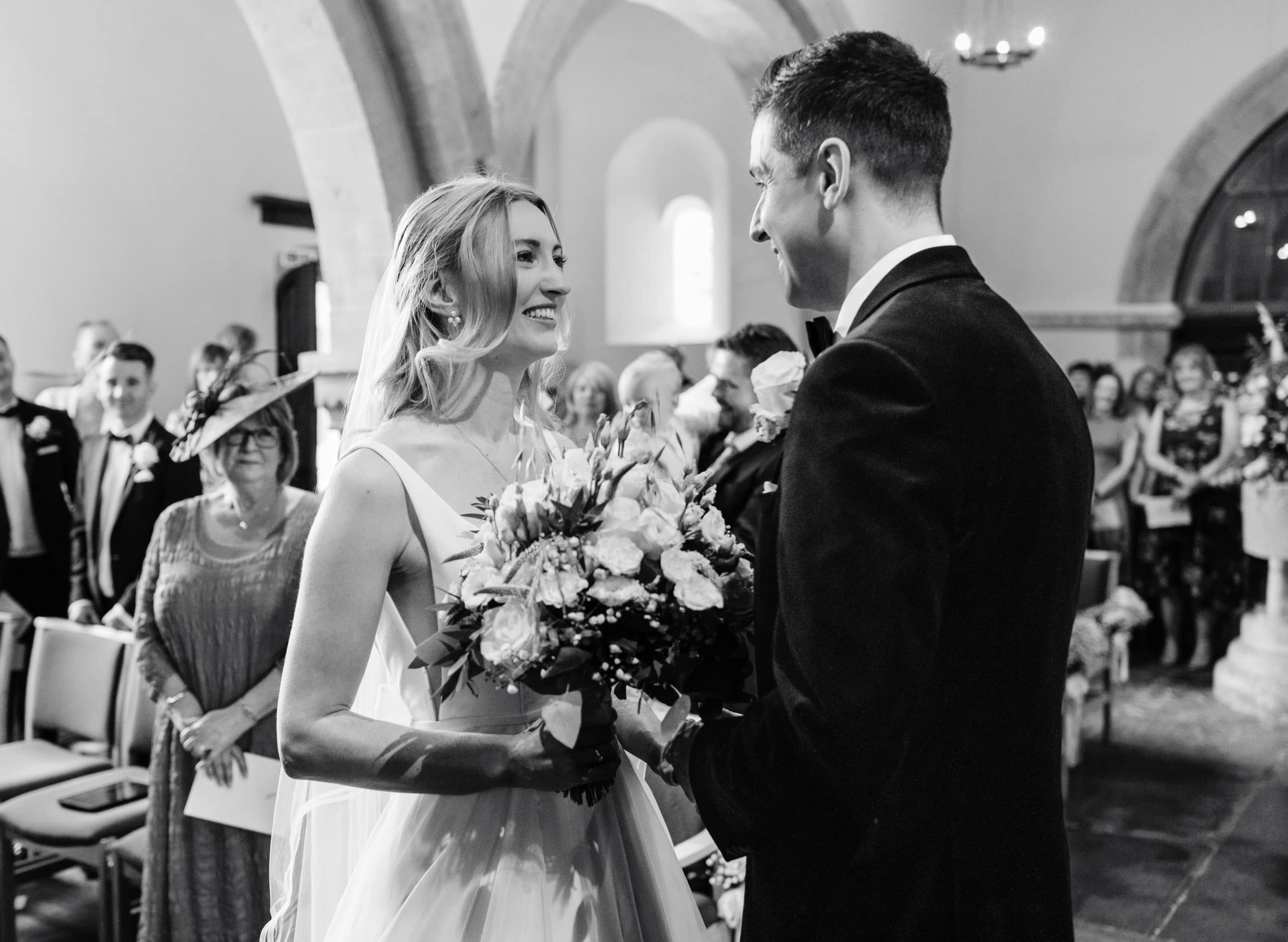 Bride and Groom stand at the alter at St Peter's Church, Welford on Avon